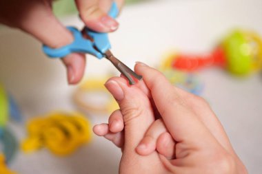 Bebek tırnaklarını kesmek. Bebek bakımı, yeni doğmuş tırnakların kapalı çekimi..