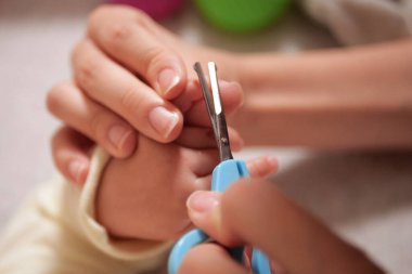 Bebek tırnaklarını kesmek. Bebek bakımı, yeni doğmuş tırnakların kapalı çekimi..