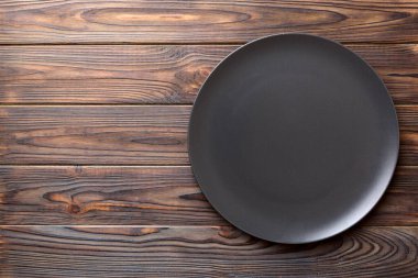 Ahşap arka plandaki siyah plakanın üst görüntüsü. Tasarımın için boş boşluk.