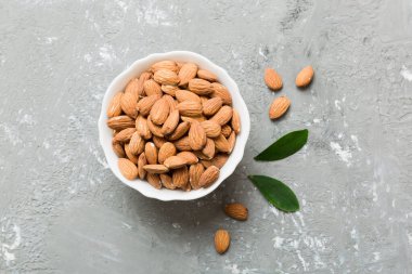 Fresh healthy Almond in bowl on colored table background. Top view.