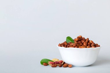 Fresh healthy peanuts in bowl on colored table background. Top view Healthy eating bertholletia concept. Super foods.