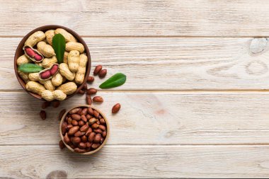 Fresh healthy peanuts in bowl on colored table background. Top view Healthy eating bertholletia concept. Super foods.