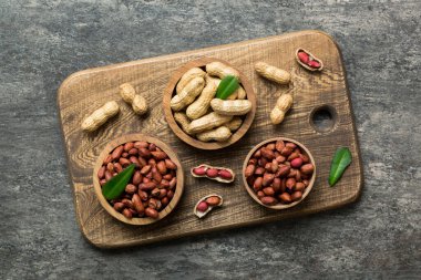 Fresh healthy peanuts in bowl on colored table background. Top view Healthy eating bertholletia concept. Super foods.