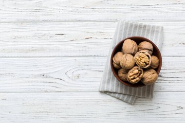 Fresh healthy walnuts in bowl on colored table background. Top view Healthy eating bertholletia concept. Super foods.