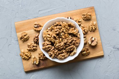 Fresh healthy walnuts in bowl on colored table background. Top view Healthy eating bertholletia concept. Super foods.