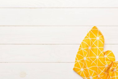 top view with yellow empty kitchen napkin isolated on table background. Folded cloth for mockup with copy space, Flat lay. Minimal style.