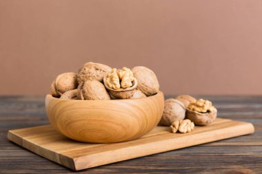 Fresh healthy walnuts in bowl on colored table background. Top view Healthy eating bertholletia concept. Super foods.