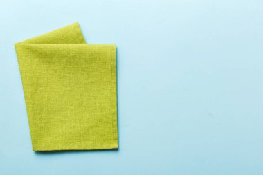 top view with green kitchen napkin isolated on table background. Folded cloth for mockup with copy space, Flat lay. Minimal style.