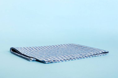top view with blue kitchen napkin isolated on table background. Folded cloth for mockup with copy space, Flat lay. Minimal style.