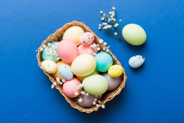 Mutlu Paskalya kompozisyonu. Paskalya yumurtaları renkli masada, çingeneyle birlikte. Doğal boyalı renkli yumurtalar arkaplan arkaplan görünümü kopya alanı ile.