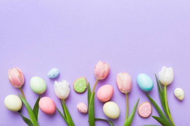 Mutlu Paskalya kompozisyonu. Renkli masada sarı laleli Paskalya yumurtaları. Doğal boyalı renkli yumurtalar arkaplan arkaplan görünümü kopya alanı ile.