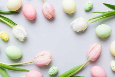Mutlu Paskalya kompozisyonu. Renkli masada sarı laleli Paskalya yumurtaları. Doğal boyalı renkli yumurtalar arkaplan arkaplan görünümü kopya alanı ile.