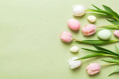 Mutlu Paskalya kompozisyonu. Renkli masada sarı laleli Paskalya yumurtaları. Doğal boyalı renkli yumurtalar arkaplan arkaplan görünümü kopya alanı ile.