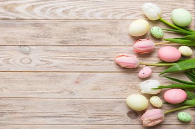 Mutlu Paskalya kompozisyonu. Renkli masada sarı laleli Paskalya yumurtaları. Doğal boyalı renkli yumurtalar arkaplan arkaplan görünümü kopya alanı ile.