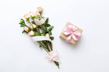 Pembe gül çiçekli tasarım konsepti ve renkli masa arkası manzaralı hediye kutusu. Mutlu Noeller, Anneler Günü, doğum günü konsepti. Romantik düz konum.