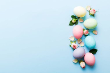 Mutlu Paskalyalar. Renkli masada sarı güllü Paskalya yumurtaları. Doğal boyalı renkli yumurtalar arkaplan arkaplan görünümü kopya alanı ile.