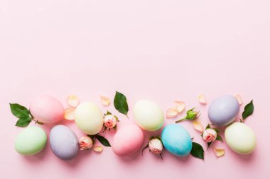Mutlu Paskalyalar. Renkli masada sarı güllü Paskalya yumurtaları. Doğal boyalı renkli yumurtalar arkaplan arkaplan görünümü kopya alanı ile.