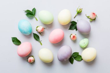 Mutlu Paskalyalar. Renkli masada sarı güllü Paskalya yumurtaları. Doğal boyalı renkli yumurtalar arkaplan arkaplan görünümü kopya alanı ile.
