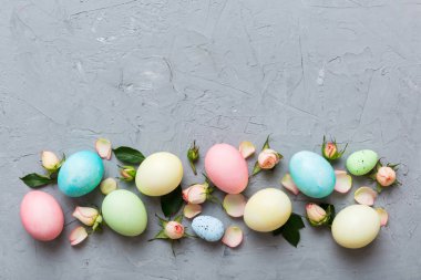Mutlu Paskalyalar. Renkli masada sarı güllü Paskalya yumurtaları. Doğal boyalı renkli yumurtalar arkaplan arkaplan görünümü kopya alanı ile.