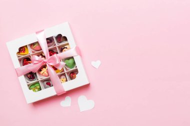 Valentine day composition: sweet candy, with gift boxes with bow and red felt hearts, photo template, background. Top View with copy space.