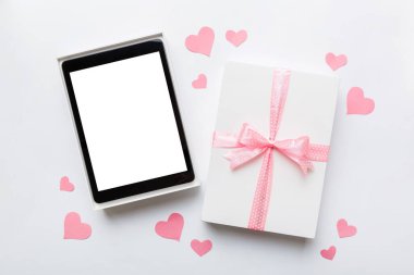 Gift box of open tablet for the holidays with a bow top view.