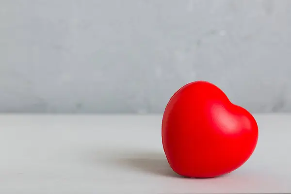 stock image gift box with red bow and red heart on colored background. Perspective view. Flat lay.