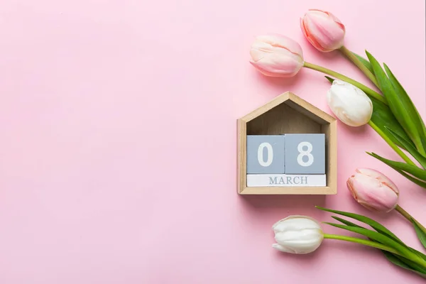 stock image 8 March, International Women's Day. greeting card design with tulips and calendar top view, with copy space.