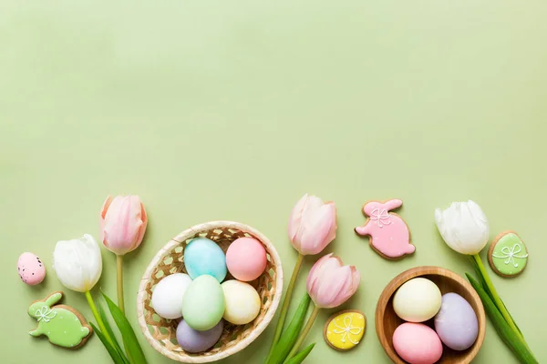 stock image Easter frame with eggs, gift box and tulip on a colored background. The minimal concept. Top view Happy Easter composition. Card with a copy space of the place for the text.