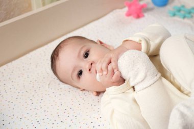 Mutlu yeni doğan bebek komik bir surat yapıyor. Odasında emekleyen bir bebeğin portresi. Yaklaş..