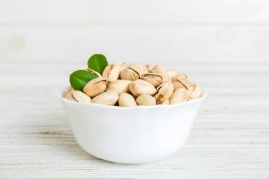 Fresh healthy Pistachios in bowl on colored table background. Top view. Healthy eating concept. Super foods.