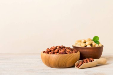 Fresh healthy peanuts in bowl on colored table background. Top view Healthy eating bertholletia concept. Super foods.
