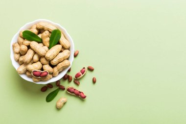 Fresh healthy peanuts in bowl on colored table background. Top view Healthy eating bertholletia concept. Super foods.