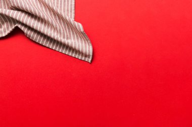 top view with red empty kitchen napkin isolated on table background. Folded cloth for mockup with copy space, Flat lay. Minimal style.