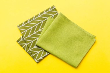 top view with green kitchen napkin isolated on table background. Folded cloth for mockup with copy space, Flat lay. Minimal style.