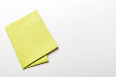 top view with green kitchen napkin isolated on table background. Folded cloth for mockup with copy space, Flat lay. Minimal style.