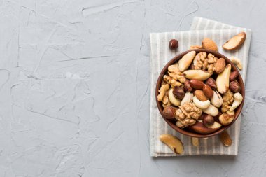 mixed nuts in bowl. Mix of various nuts on colored background. pistachios, cashews, walnuts, hazelnuts, peanuts and brazil nuts.