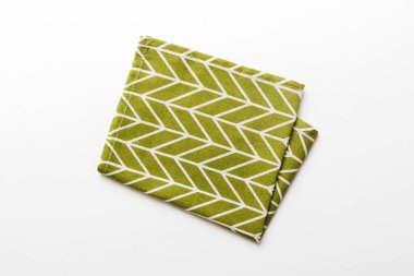 top view with green kitchen napkin isolated on table background. Folded cloth for mockup with copy space, Flat lay. Minimal style.