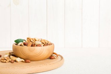 mixed nuts in bowl. Mix of various nuts on colored background. pistachios, cashews, walnuts, hazelnuts, peanuts and brazil nuts.