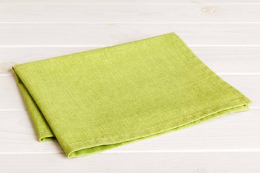 top view with green kitchen napkin isolated on table background. Folded cloth for mockup with copy space, Flat lay. Minimal style.