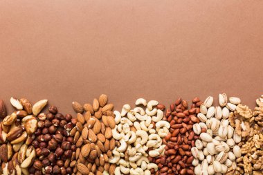 different nuts frame background. Close up, top view, flat lay with vopy space. Walnut, pistachios, almonds, hazelnuts and cashews.