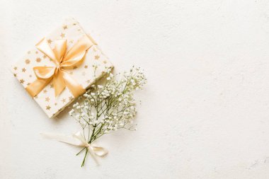 Hediye kutusu ya da hediye kutusu ve çiçek çıngıraklı yılanı ışık masasının üstünde. Tebrik kartı. Kopya alanı ile düz uzanma biçimi.