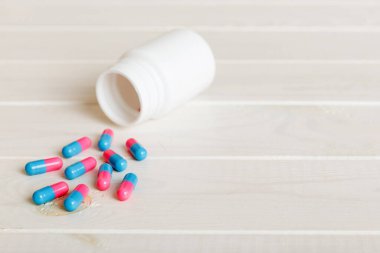 plastic medicine bottle with capsules of pills on colored background. Online pharmacy. Painkiller medicine and antibiotic drug resistance concept. Pharmaceutical industry.