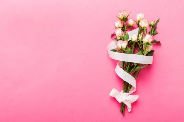 Renkli arka planda pembe buket ve beyaz güller. Anneler günü, sevgililer günü, doğum günü kutlaması konsepti. Tebrik kartı. Metin için boşluk kopyala, üst görünüm.