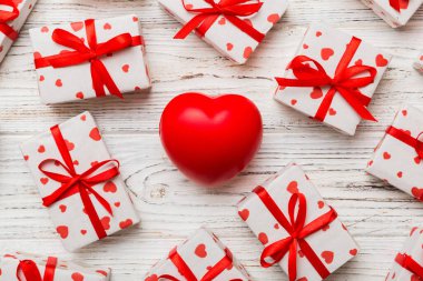 gift box with red bow and red heart on colored background . Top view. Flat lay.