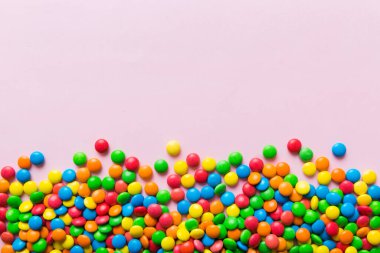 Renkli arka planda karışık renkli şeker koleksiyonu. Düz yerde, üst tarafta. Renkli çikolata kaplı şeker çerçevesi.
