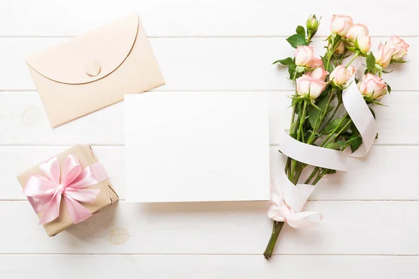 stock image Greeting holiday card mockup with fresh roses on colored table background, mock up with copy space for design.