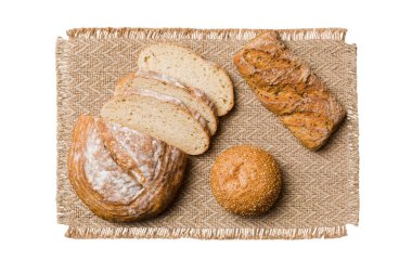 Beyaz arka planda izole edilmiş peçeteyle taze pişmiş ekmek dilimleri. Üst görünüm Dilimlenmiş ekmek.