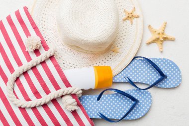 Plaj aksesuarları renkli arka plan yaz seyahati konseptinde düz bir görünüm sergiliyordu. İçinde deniz yıldızı ve deniz kabuğu olan bir çanta. Üst görünüm.