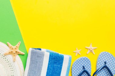 Plaj aksesuarları hasır şapka ve deniz kabuğu renkli masada. Yaz konsepti arka planı.