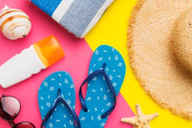 Plaj aksesuarları hasır şapka ve deniz kabuğu renkli masada. Yaz konsepti arka planı.